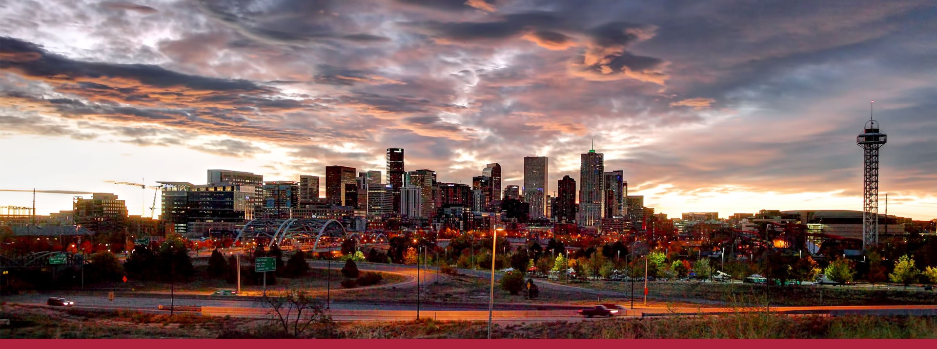 Denver skyline under dramatic clouds at dusk
