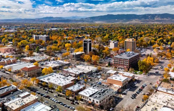 Aerial view of downtown Fort Collins with autumn foliage and the Front Range