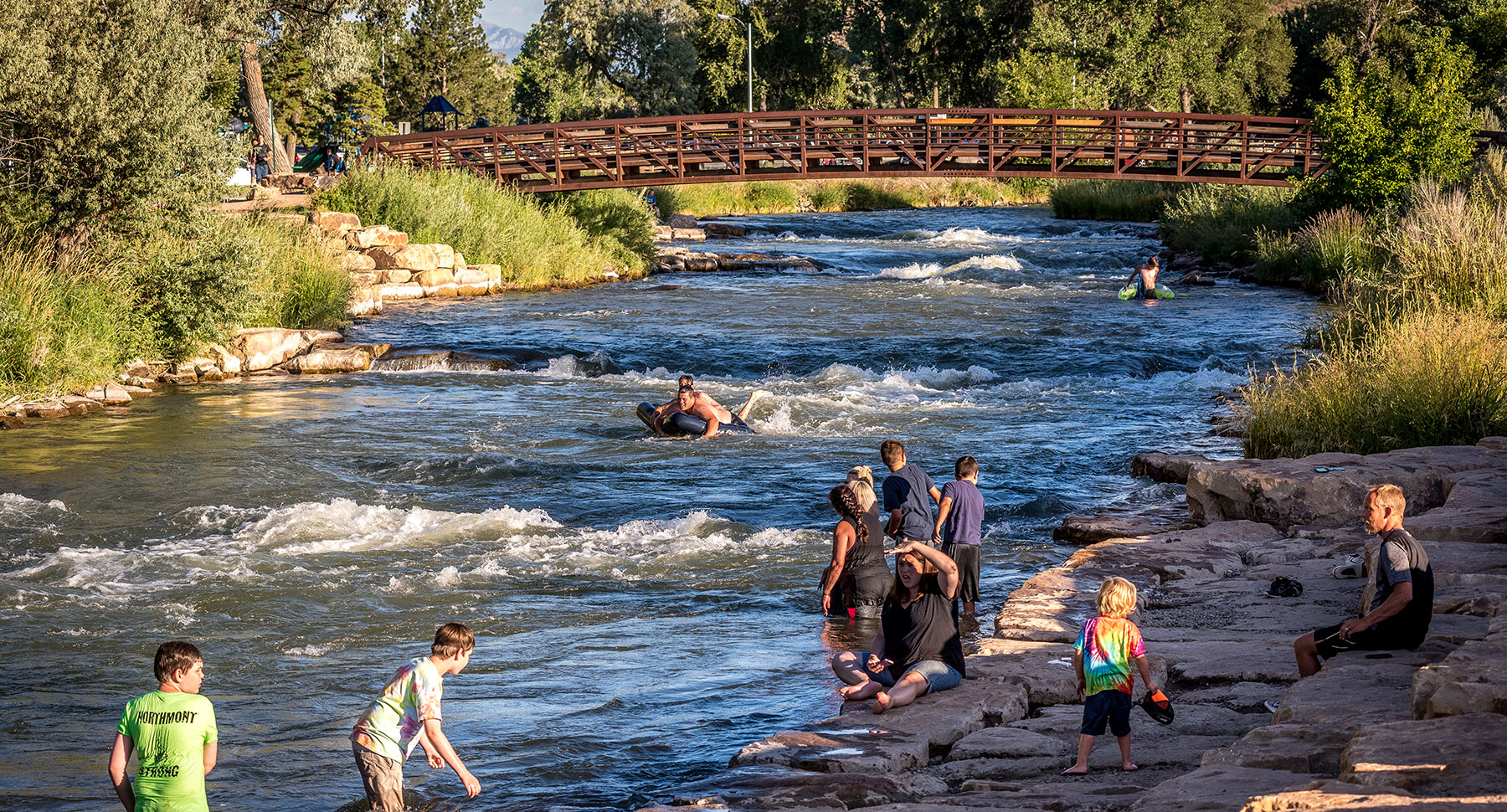 Families tubing and playing at the Uncompahgre River whitewater park in downtown Montrose, Colorado