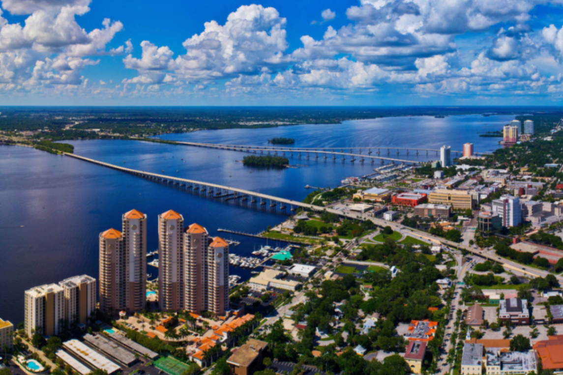 Aerial view of downtown Fort Myers along the Caloosahatchee River with high-rise condos and the bridge
